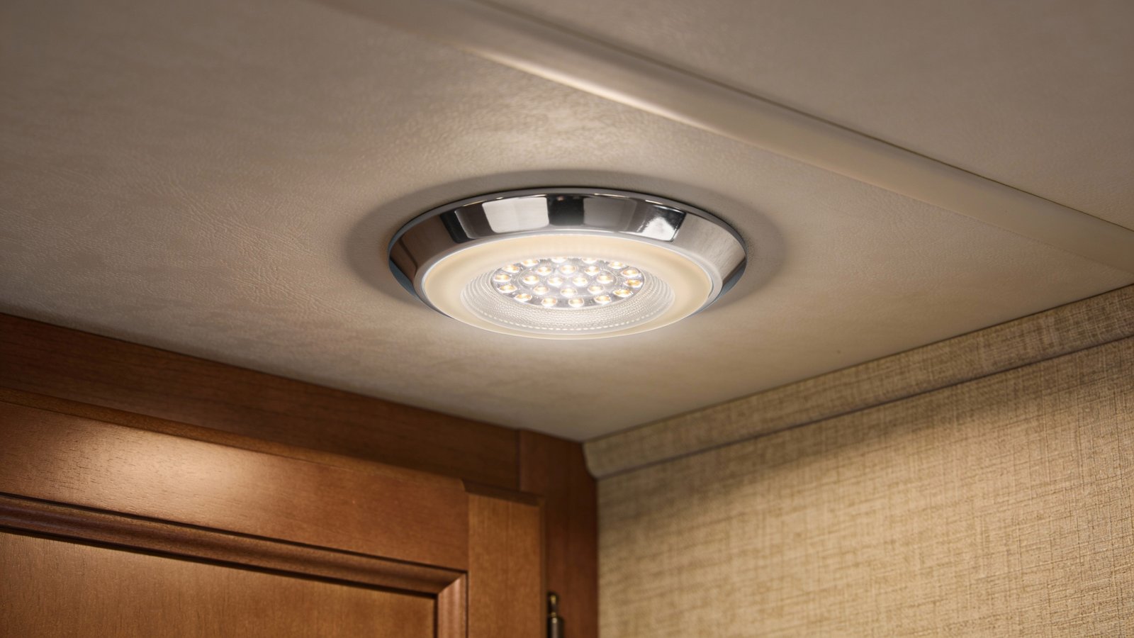 **Detailed shot of energy-efficient 12V LED puck light in RV bedroom**